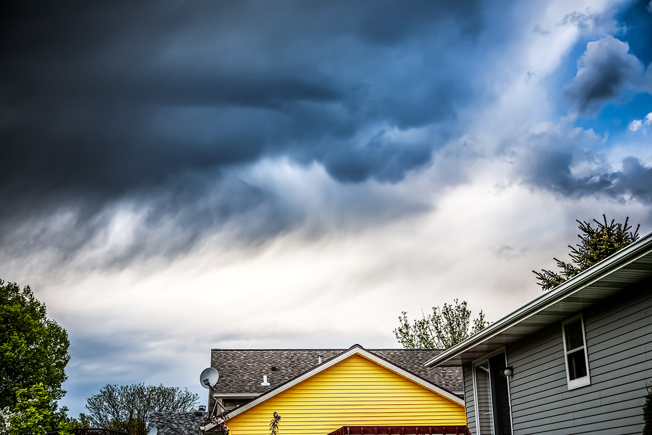 yellow house with storm clouds